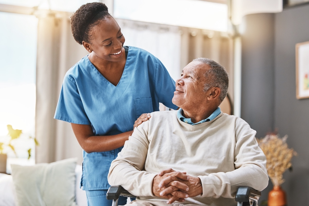 Nurse talking to elderly man in wheelchair