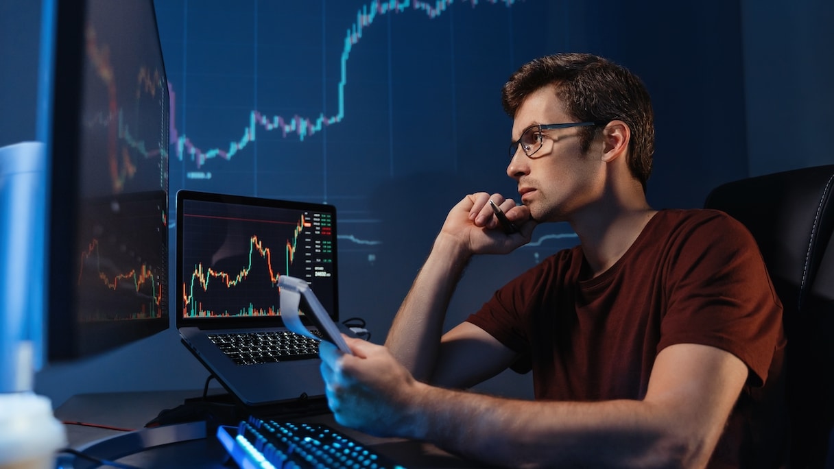 Man staring at stock ticker on computer